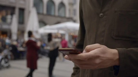 Man looking at his phone, while standing in a crowd of people. Video stock 118739050