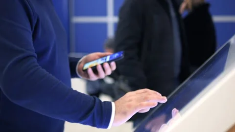 A man is looking at his phone while a child is standing next to him Stock Footage 297732643