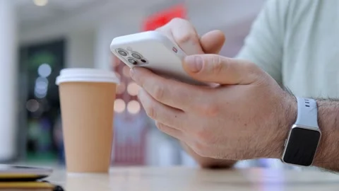 Man is looking at his phone while holding a cup of coffee Stock Footage 308871787