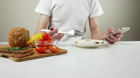 Man looking into his smartphone at breakfast. Healthy breakfast 스톡 동영상 99665183