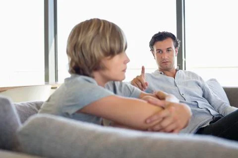Man looking at his son looking angry Stock Photos