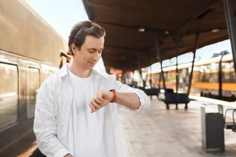 Man looking at his watch on a train platform. Male passenger waiting for tr.. Stock Photos