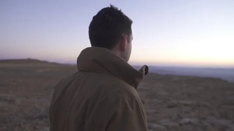 Man looking at the horizon in a cold desert morning Video stock 73079927