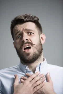 Man is looking imploring over gray background Stock Photos