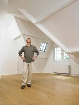 Man looking up inside empty white loft. Stock Photos