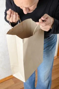 Man Looking Inside a Paper Bag 库存照片