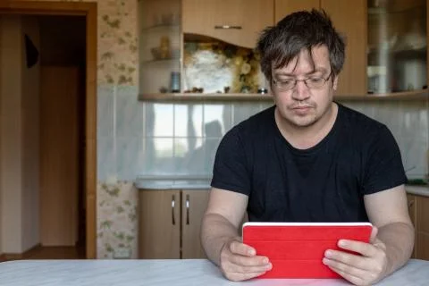 Man looking intently at the screen of the tablet Stock Photos
