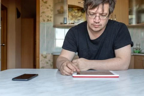 Man looking intently at the screen of the tablet Stock Photos