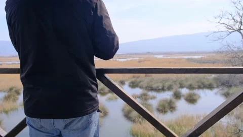 A man looking to Karacabey floodplain from bird watching tower Stock Footage 152956949