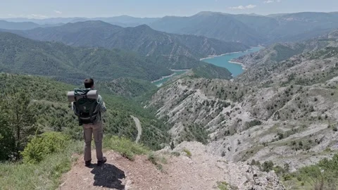 Man looking at a lake from a rock 스톡 동영상 277281130