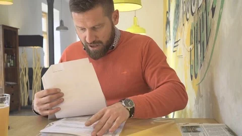 Man looking for lost documents in a hurry, in pub, cafe, indoor, stedicam 库存影片 73228180