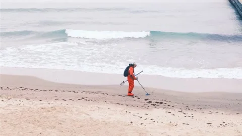 Man is looking for the lost luxuries with electronic metal detector on the beach Stock-Footage 165408724