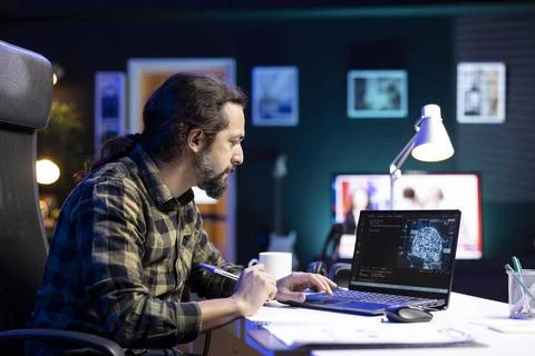 Man looking at machine code on laptop 写真素材