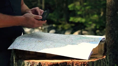 Man looking at map and compass in the woods Stock-Footage 7909097