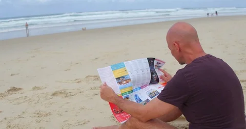 Man looking at map on beach Stock Footage 87896529