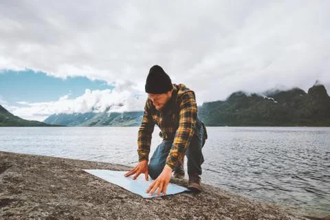Man looking at map planning vacation route trip traveling solo in Norway acti Stock Photos