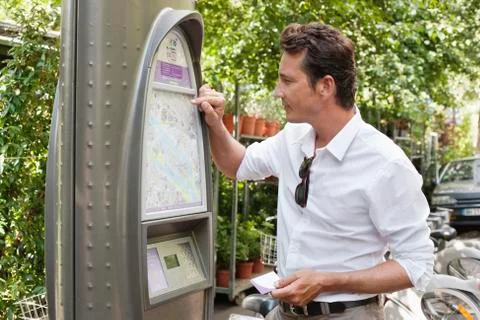 Man looking a map in a ticket machine, Paris, Ile-de-France, France Foto stock