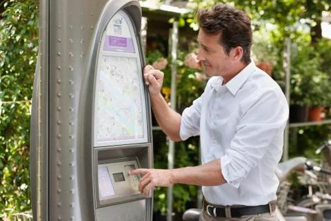 Man looking a map in a ticket machine, Paris, Ile-de-France, France 库存照片
