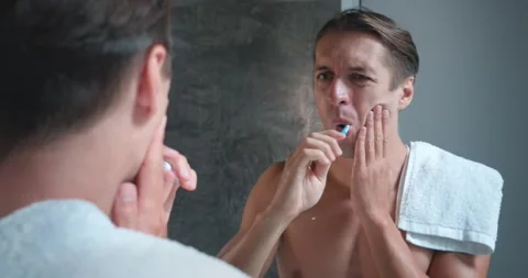 Man looking at mirror at bathroom while practicing oral hygiene encounters Stock Footage 263901059