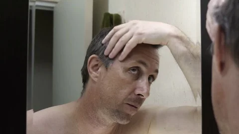 Man Looking in Mirror at His Gray Hair 動画素材 72292081