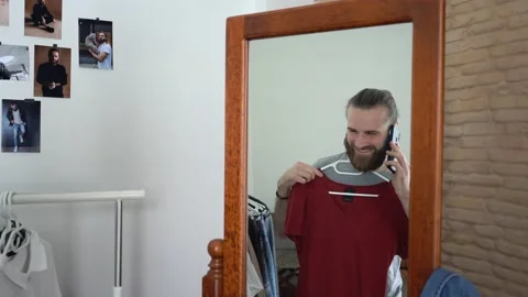Man looking into the mirror Putting together an outfit Stock Footage 147893987