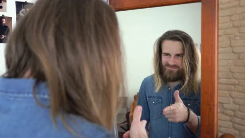 Man  is looking into the mirror Putting together an outfit Stock Footage 147896208