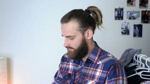 Man is looking into the mirror Putting together outfit with new shirt Stock Footage 147898238