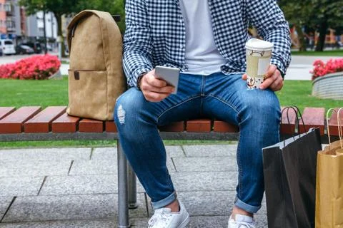 Man looking mobile sitting on a bench Stock Photos