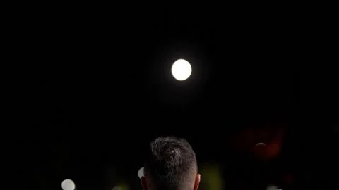 A man looking at the moon at night Stock Footage 203855879