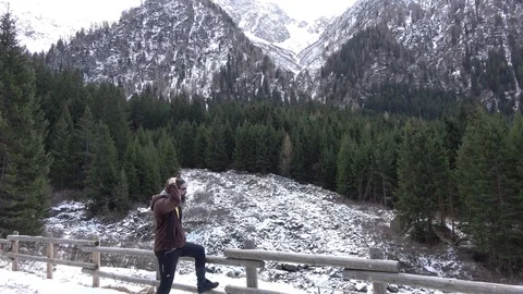 Man looking at mountains with snow 4k Vidéo 83960361
