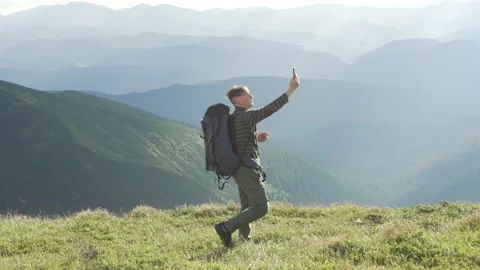 A man is looking for a network on a phone in the mountains Stock Footage 233491490