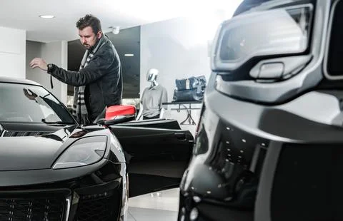 A Man Looking For a New Car Inside a Dealership Showroom 库存照片
