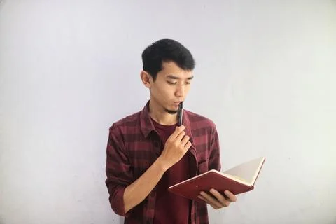 A man looking to a note book with confuse expression Stock Photos