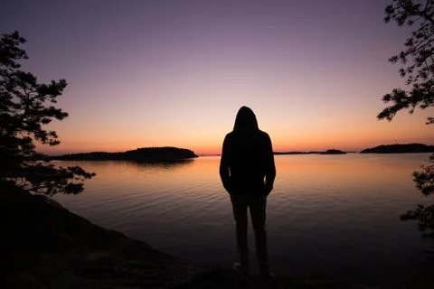 Man looking out at lake Stock Photos