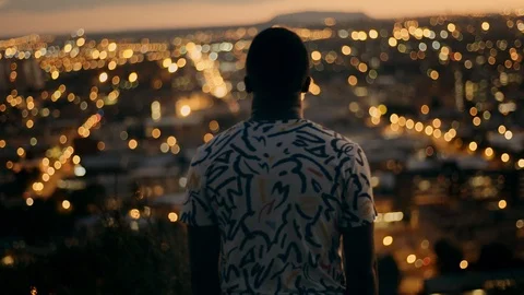 Man looking out over the city at night 스톡 동영상 89766653