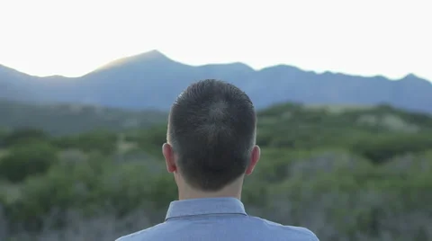 Man Looking Out Towards Sunset in Wilderness 動画素材 68723648