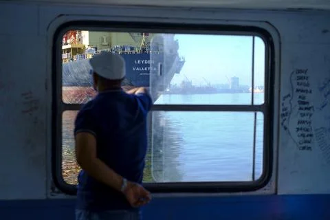Man looking out window on ferry in Havana, Cuba Stock Photos