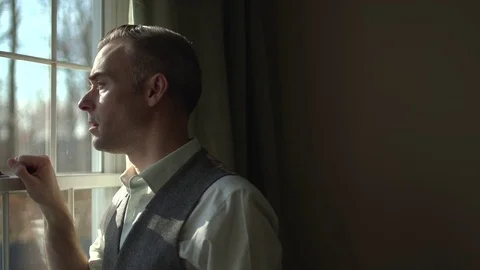 Man looking out window from inside dark room Stock Footage 70260584