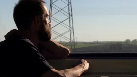 Man Looking out Window of Moving Passenger Train Carriage Stock Footage 334058327
