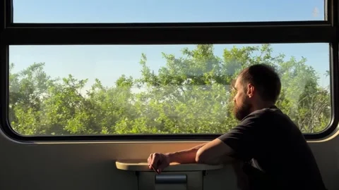 Man Looking out Window of Moving Passenger Train Carriage Vídeo Stock 334058332