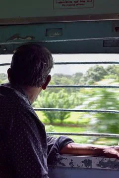 Man looking outside through train window. Stock Photos