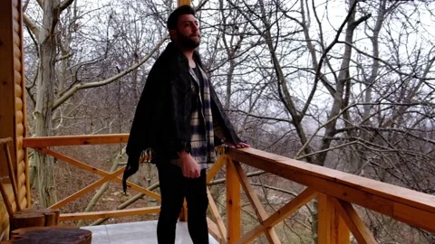 Man looking outside while it's snowing on the balcony, snowfall, balcony, Stock Footage 230010880