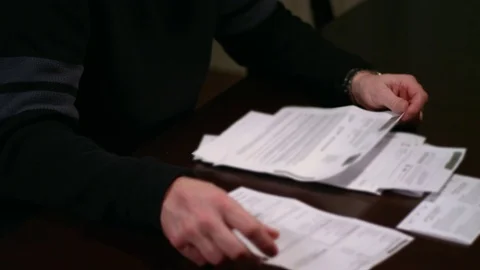 A man looking over bills at the table, looking stressed Video stock 70712597