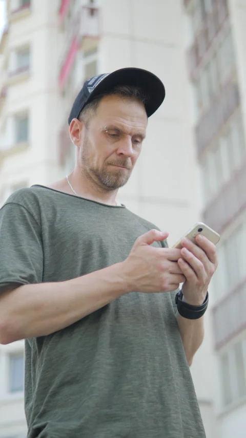 Man looking at phone with interest. vertical video Stock Footage 313359396