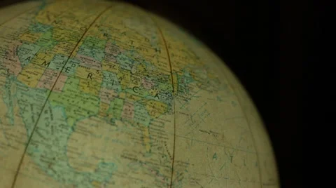 A man looking for places on a world globe map Stock Footage 57715461