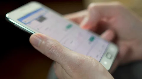 A man is looking for plane tickets on the Internet online using a smartphone cel Stock Footage 119689720