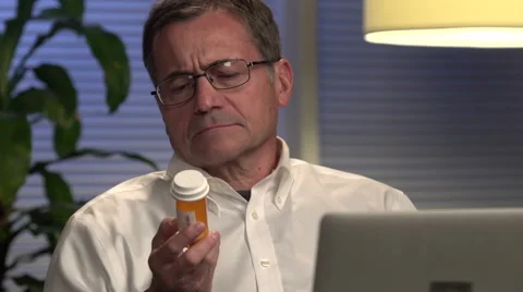 Man looking at prescription at computer Stock Footage 44018777