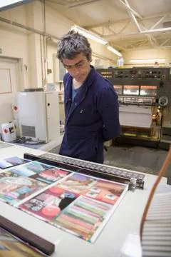 A man looking at printed samples in a factory Stock Photos