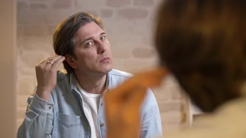 The man is looking at the problems on his skin in the bathroom. Stock Footage 132185278
