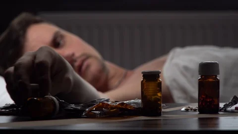 Man looking for the right medication on the table Stock Footage 125809957